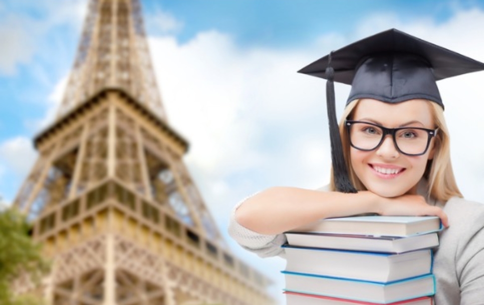 student-in-trencher-with-books-over-eiffel-tower-picture-id8822627624